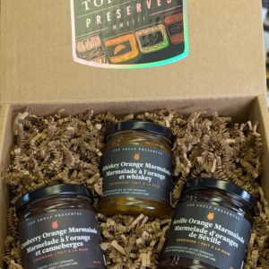 three jars of marmalade in a gift box with a holographic sticker that says "Top Shelf Preserves"