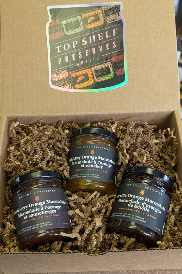 three jars of marmalade in a gift box with a holographic sticker that says "Top Shelf Preserves"